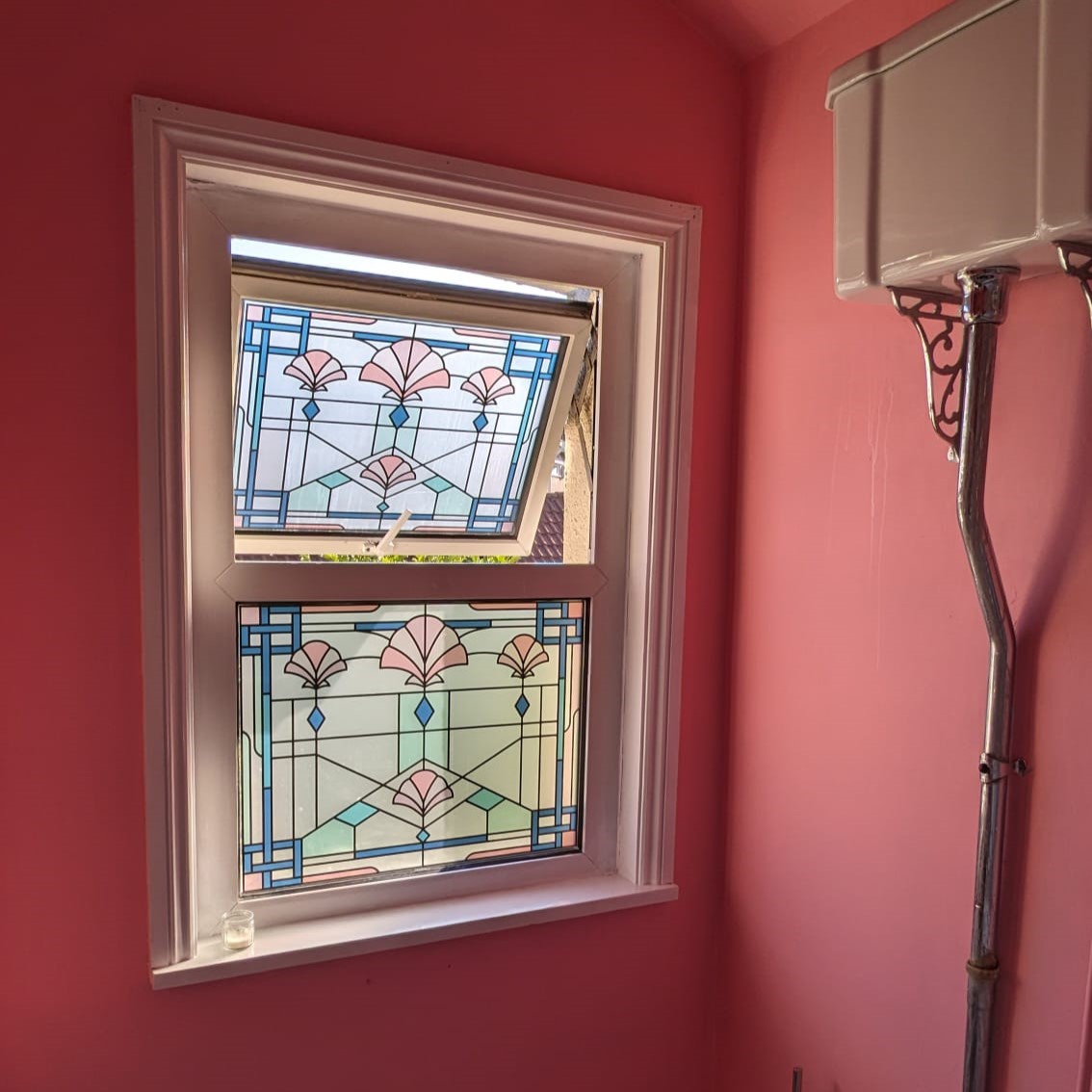 Square beatrice stained glass film installed in a bathroom with pink walls.jpg