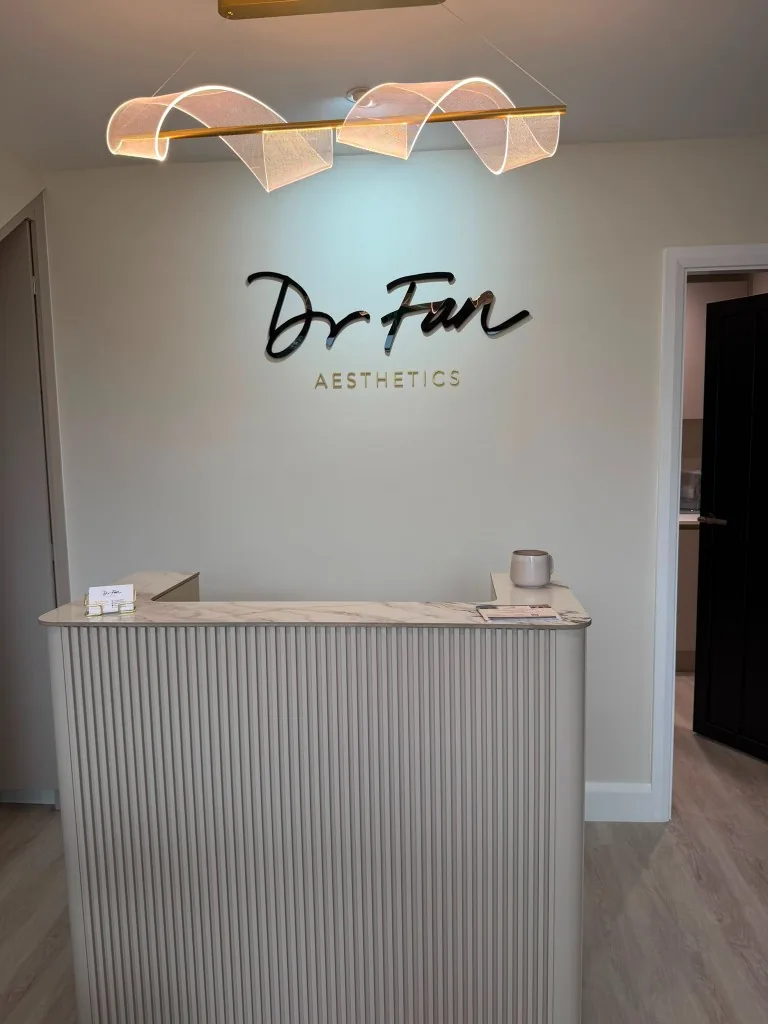 Reception desk wrapped in marble-effect architectural film with dimensional lettering